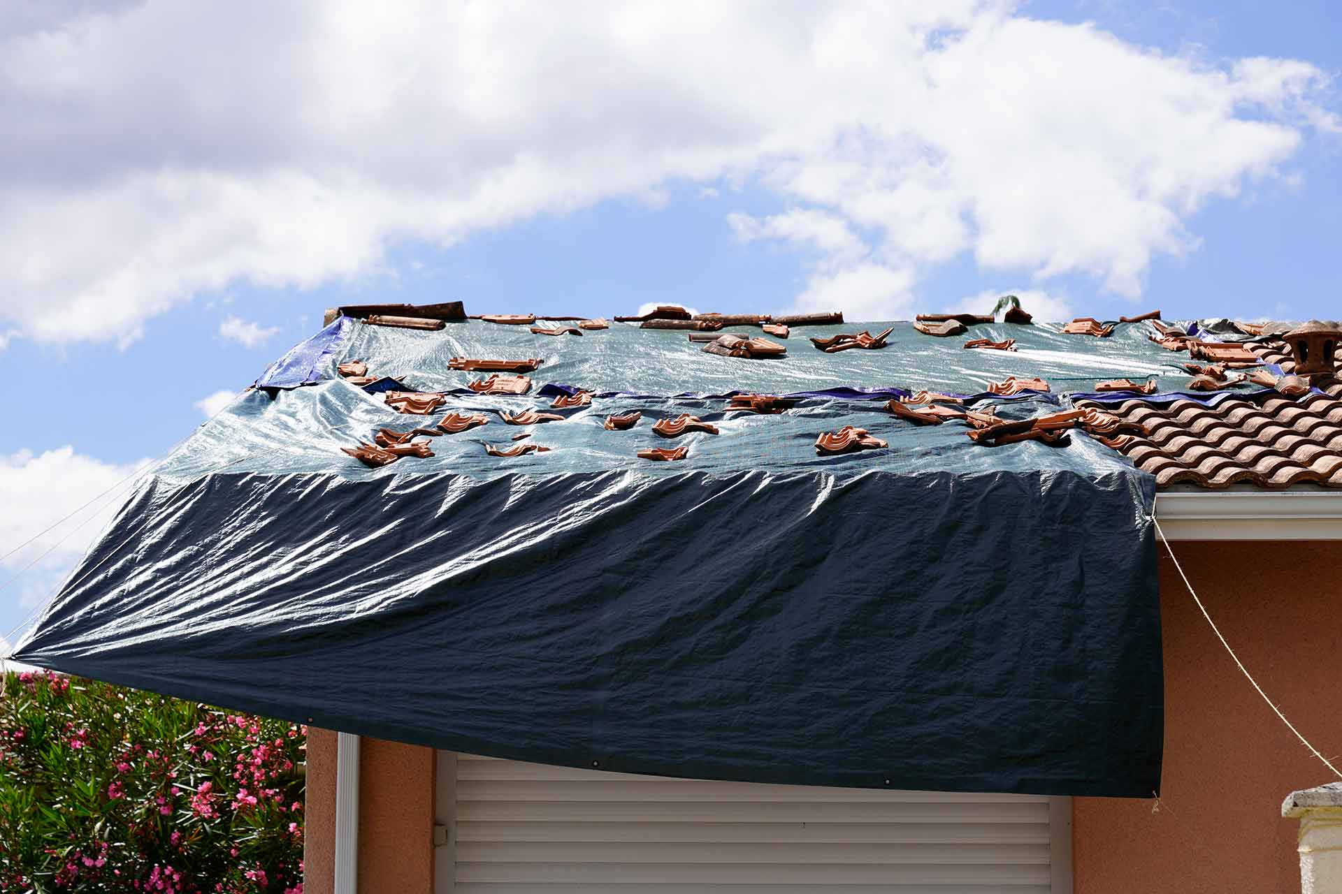 Emergency roof repair with tarpaulin on a UK house